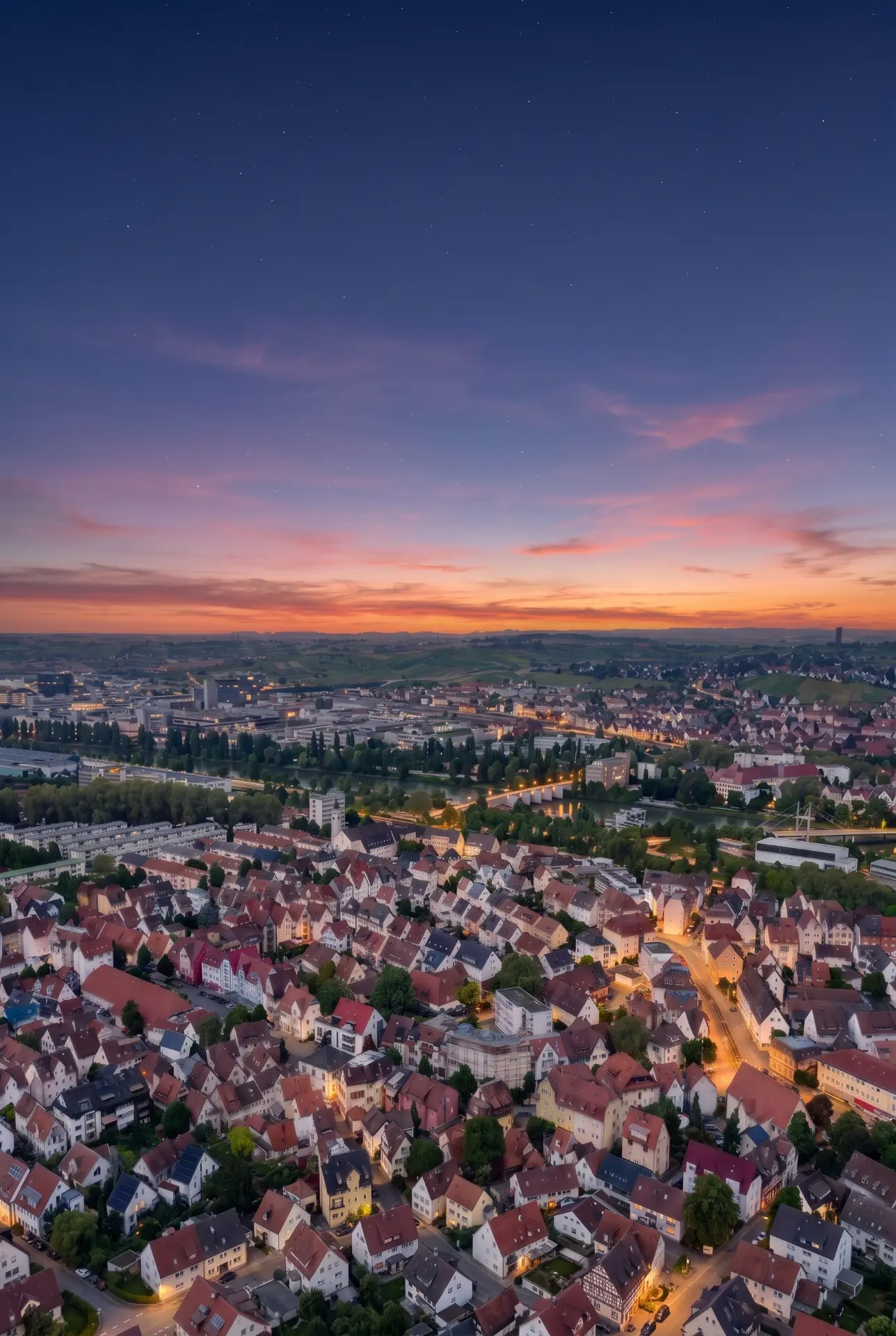 Visualisierung des Wohngebäudes in Stuttgart-Wangen im Abendlicht über den Dächern von Wangen